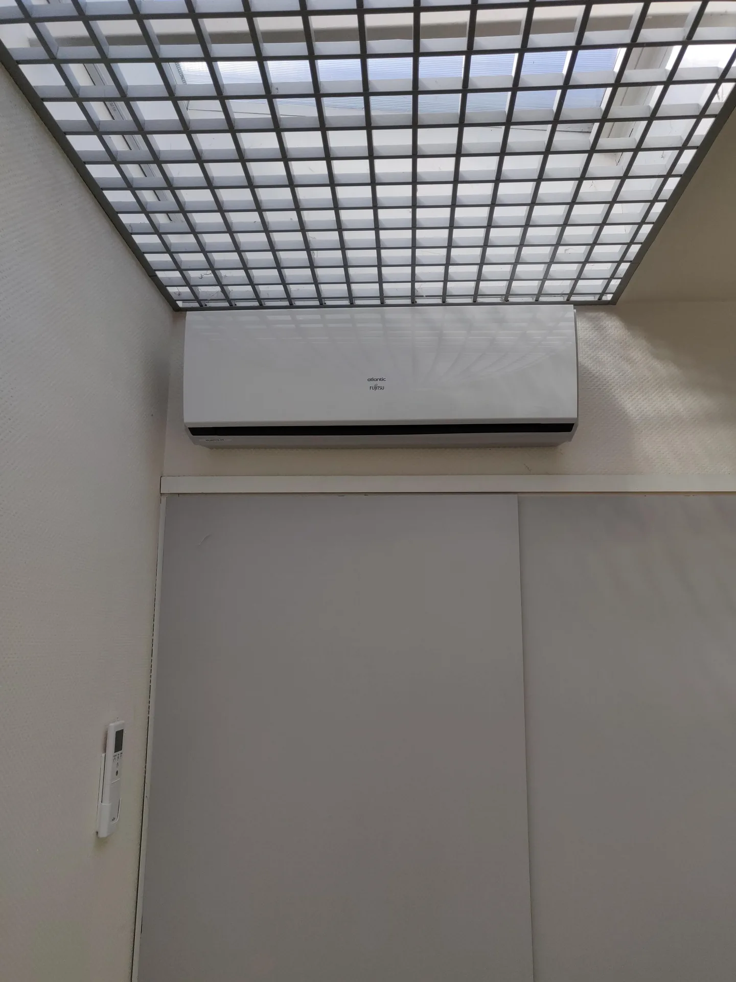 Unité intérieure murale au-dessus d'une porte, dans des bureaux à Jarrie, climatisation multi-split Fujitsu par Air Eco Clim
