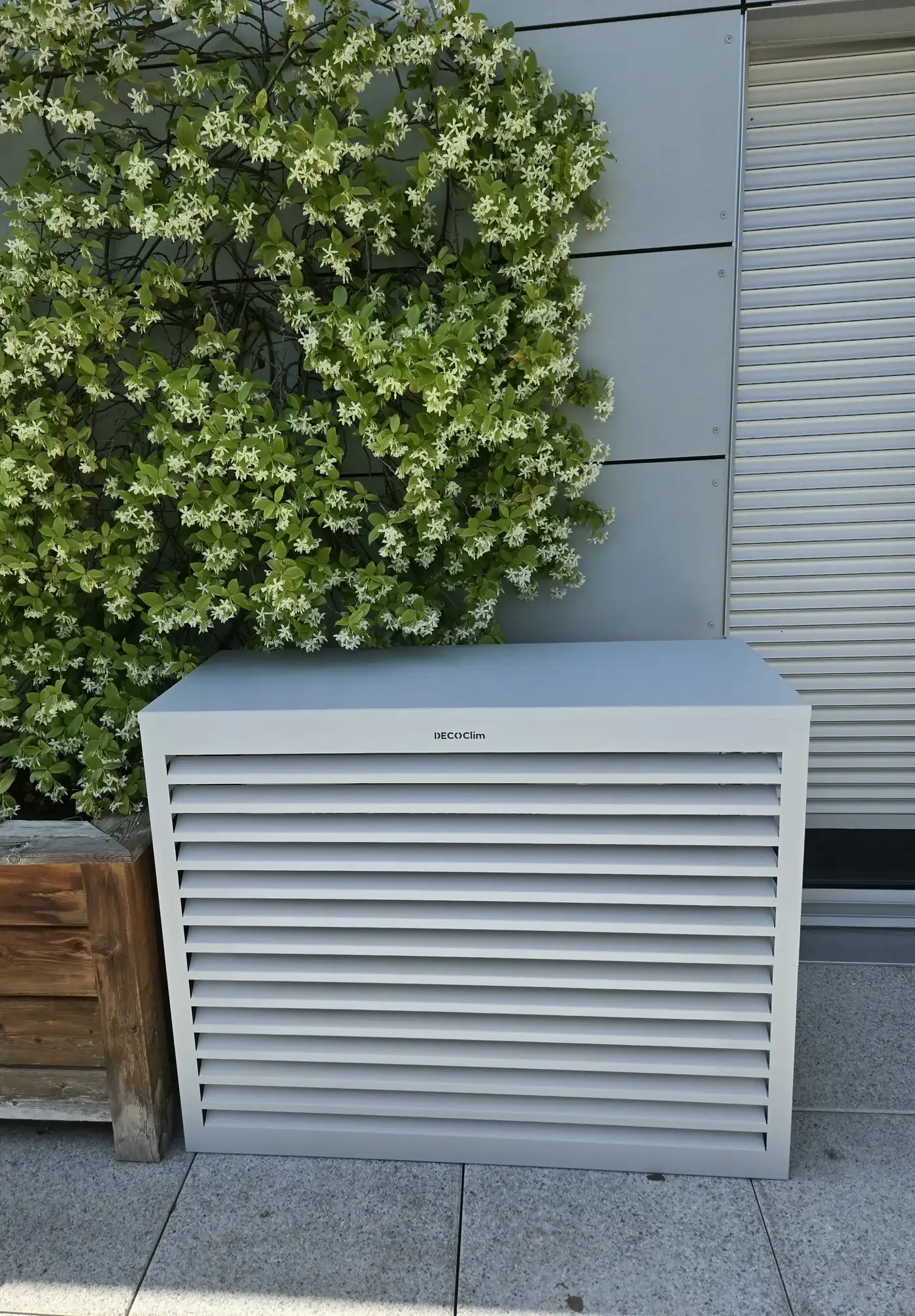 Groupe extérieur Toshiba habillé d'un cache design DecoClim sur la terrasse d'un appartement à Corenc — aucun tube visible
